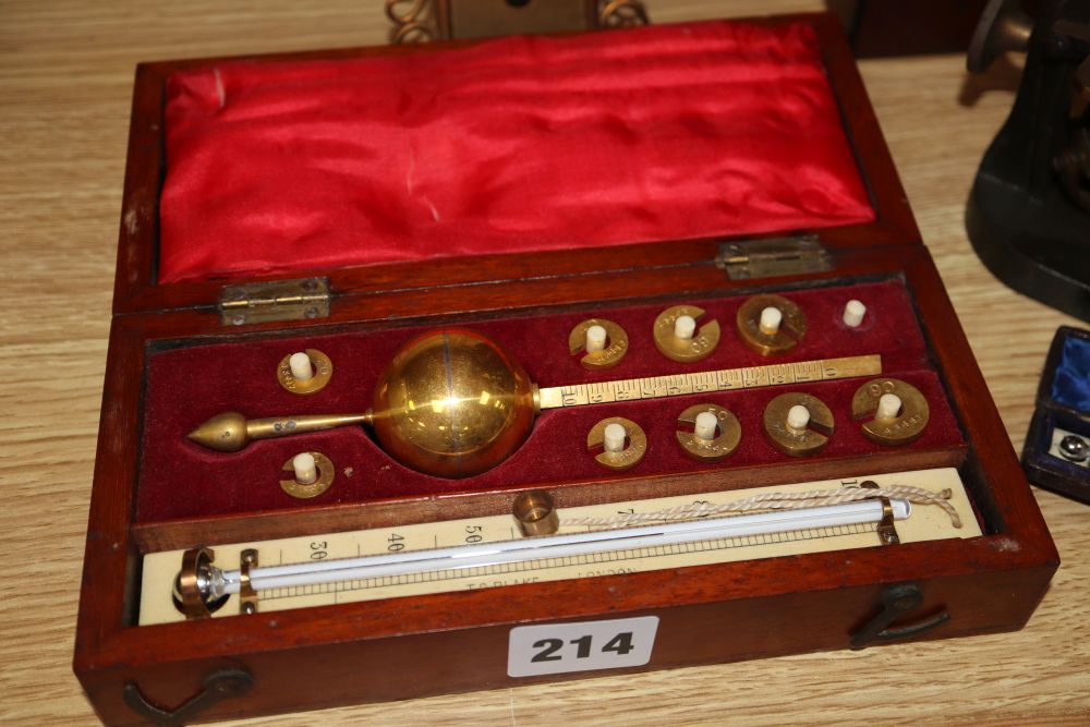 A cased microscope, a cased Sikes hydrometer and two thermometers